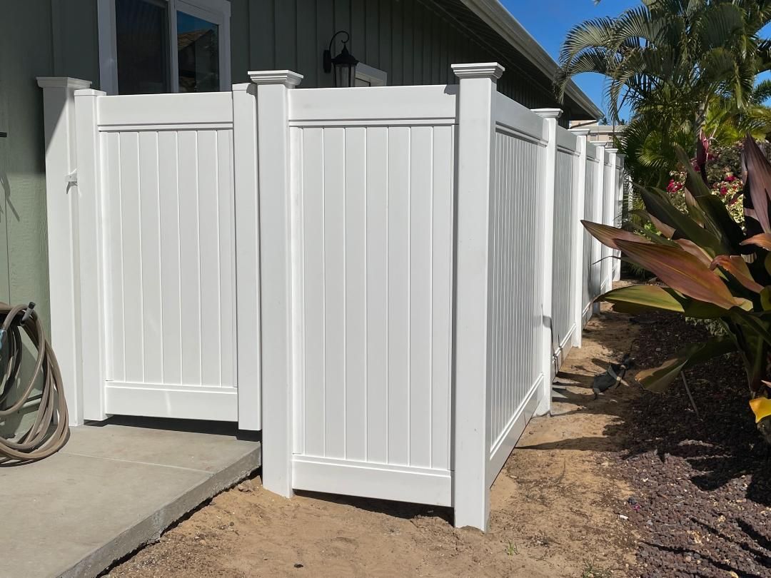 A white fence is sitting in front of a house.