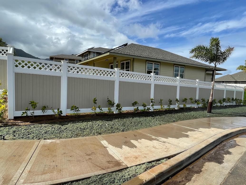 A house with a fence around it and a sidewalk in front of it.