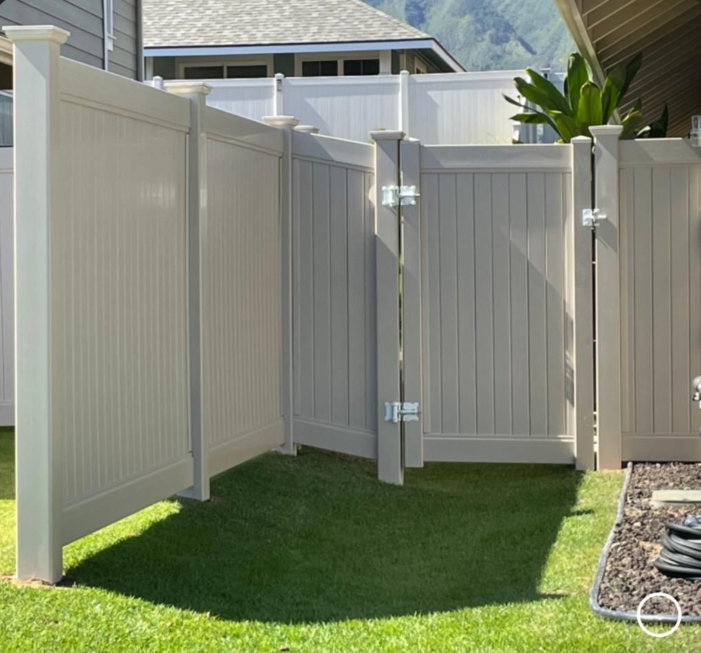 A white fence surrounds a lush green yard