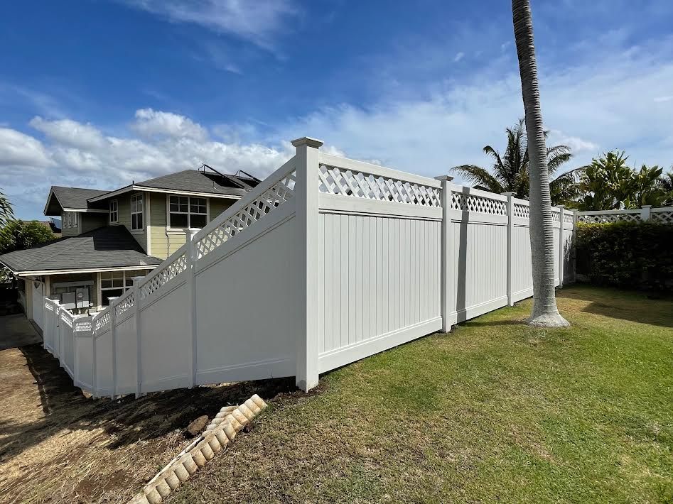 A white fence is sitting in front of a house.