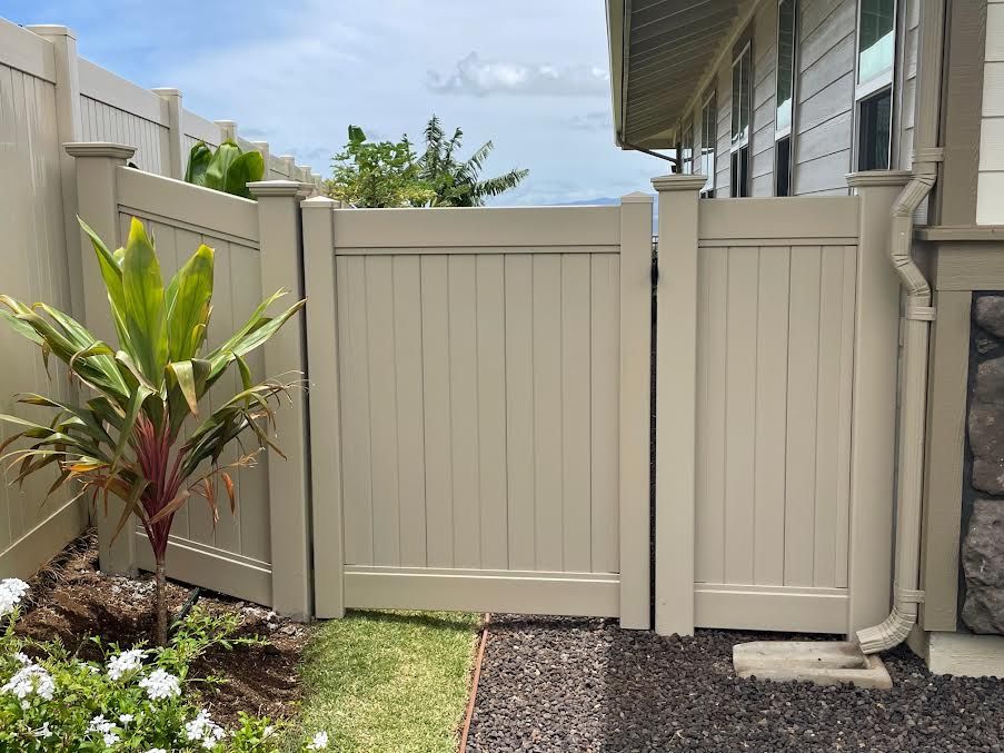 A white fence with a gate in front of a house.