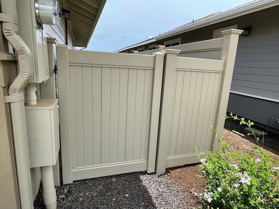 A white fence is sitting next to a house.