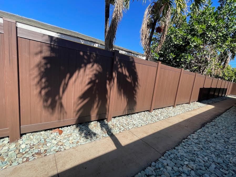 A wooden fence with a palm tree shadow on it