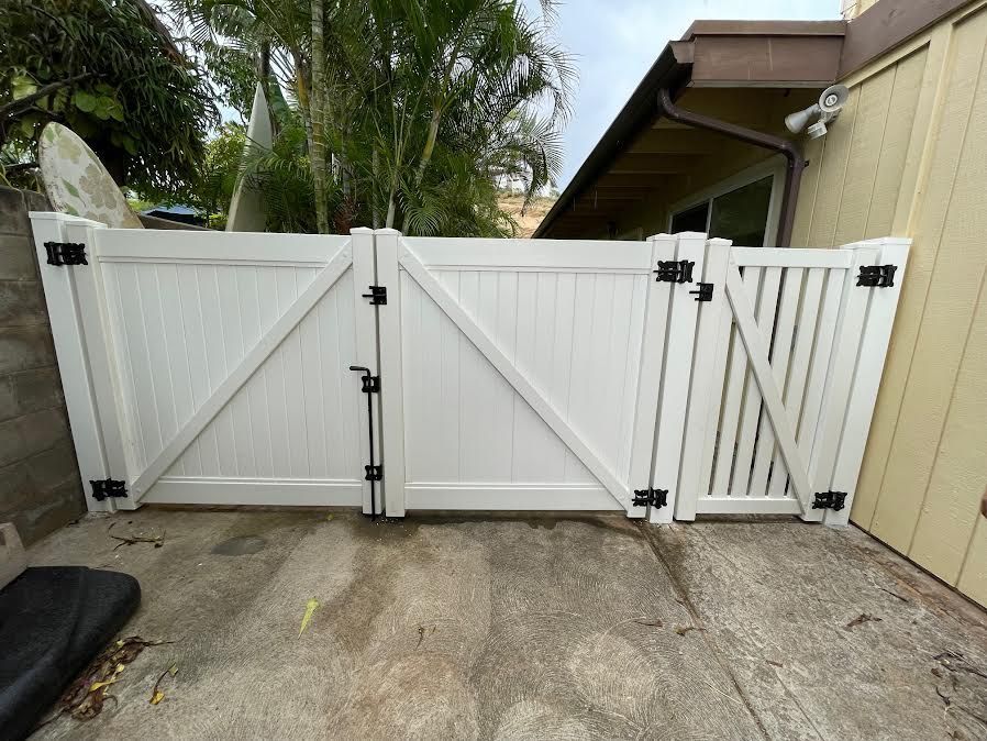 A white gate is sitting in front of a house.