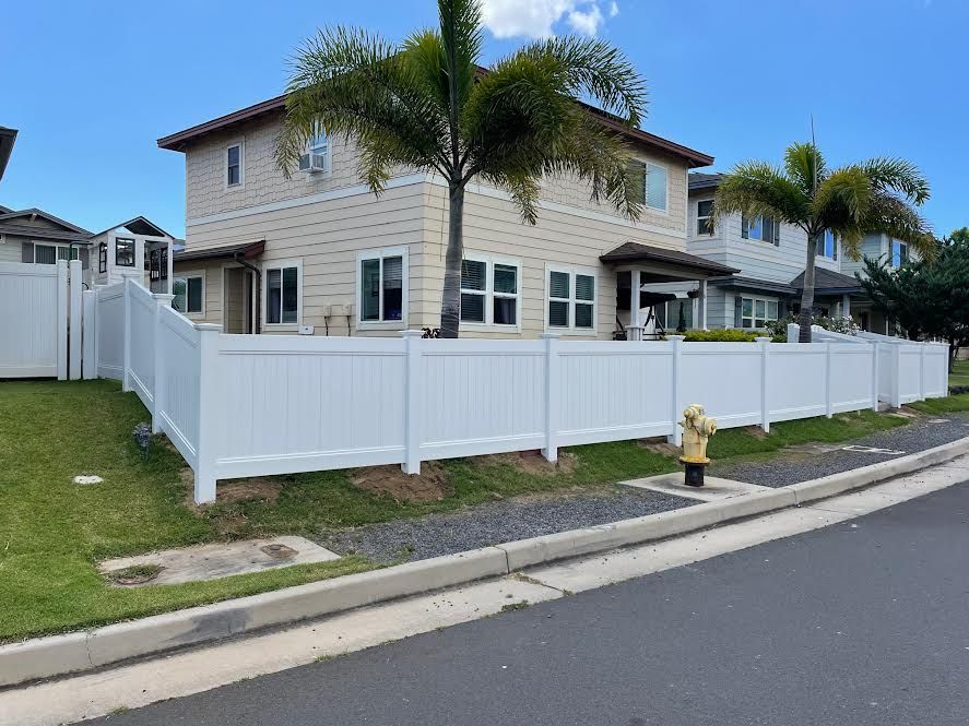 There is a white fence in front of a house.