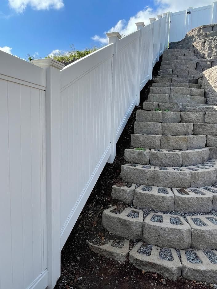 A white fence surrounds a set of stone stairs.
