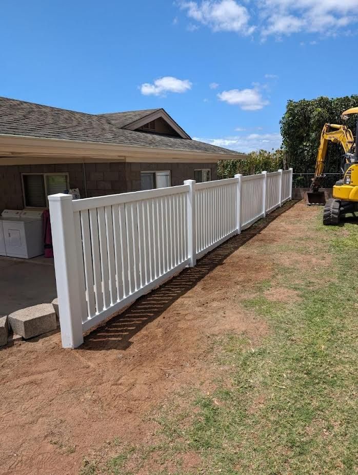 A white fence is being built in front of a house.