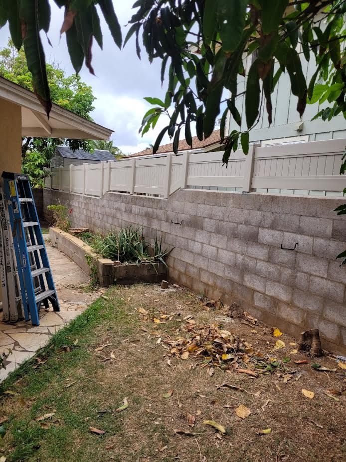 A ladder is sitting next to a brick wall in a backyard.
