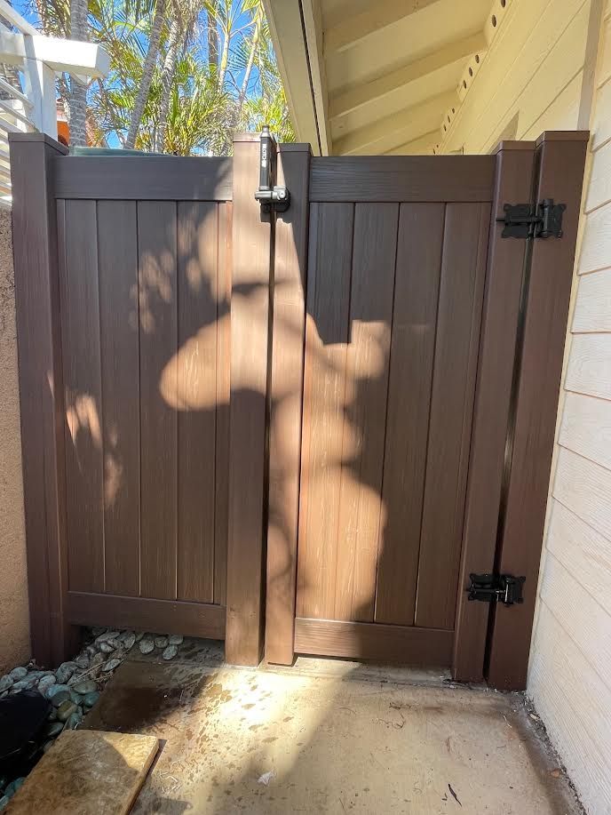 A wooden gate with a shadow of a person on it.