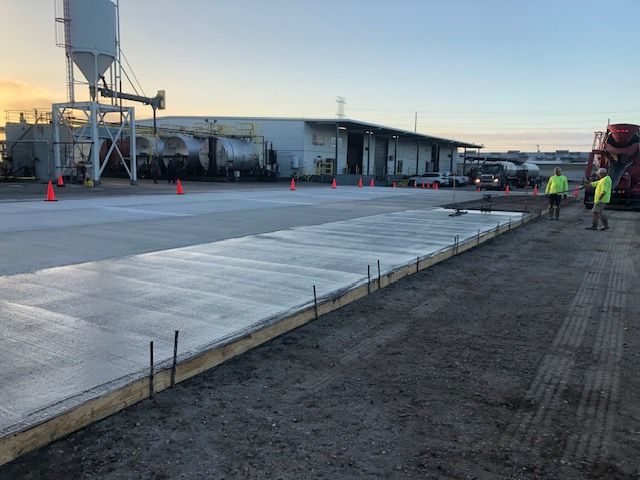 A concrete driveway is being built in front of a building.