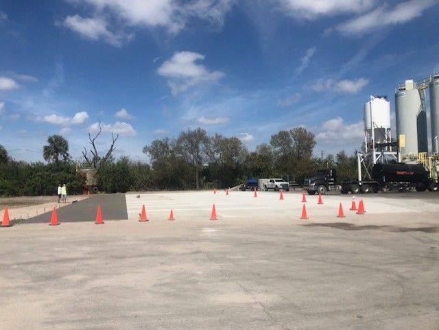 A lot of orange cones are on the ground in a parking lot.