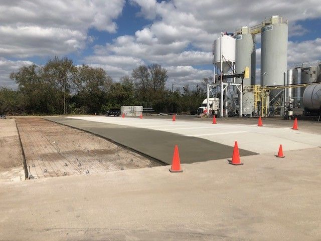 A concrete driveway is being built in front of a factory.