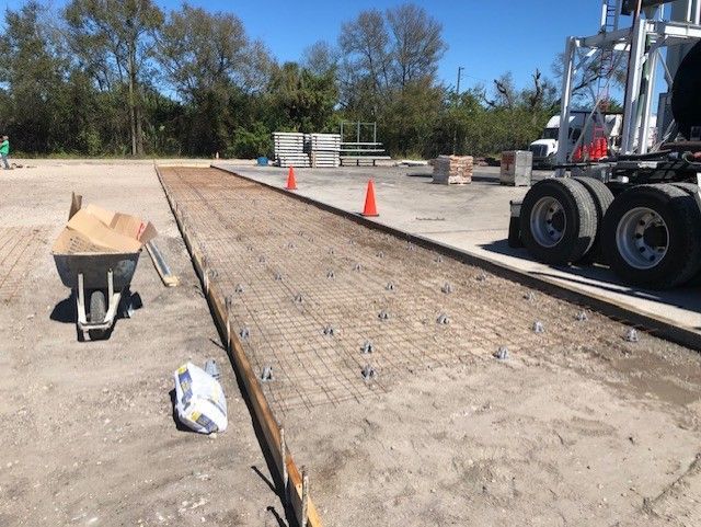A forklift is parked on the side of a dirt road.