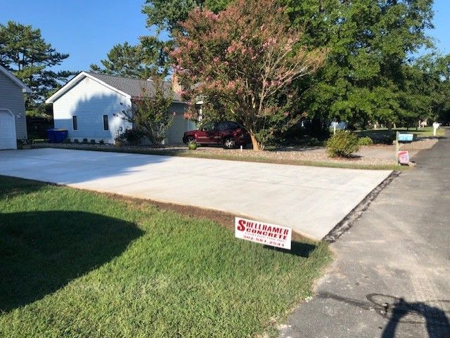A concrete driveway is being built in front of a house.