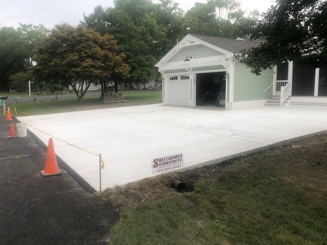 A concrete driveway is being built in front of a house.