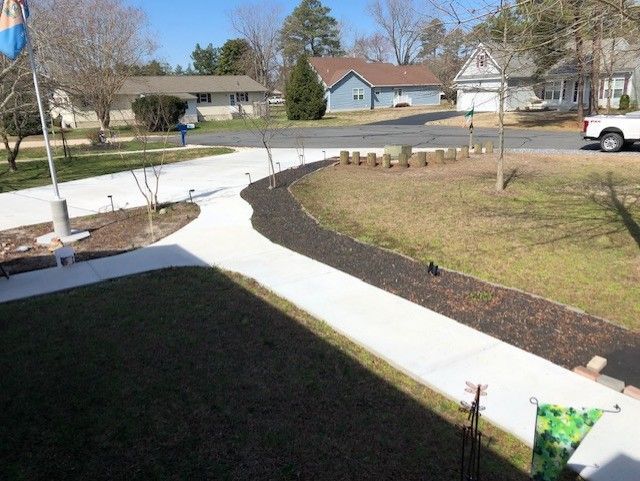 A white truck is parked on the side of the road next to a sidewalk