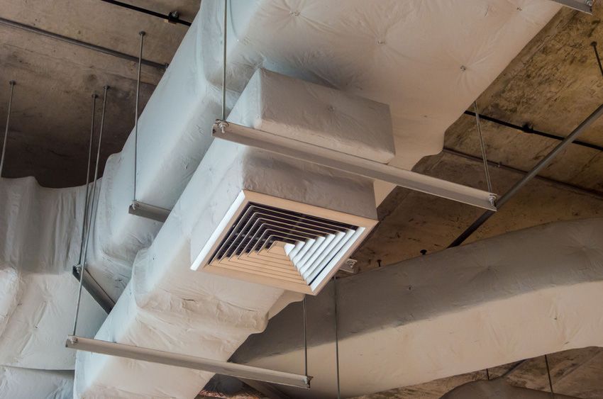 A ventilation system is hanging from the ceiling of a building.