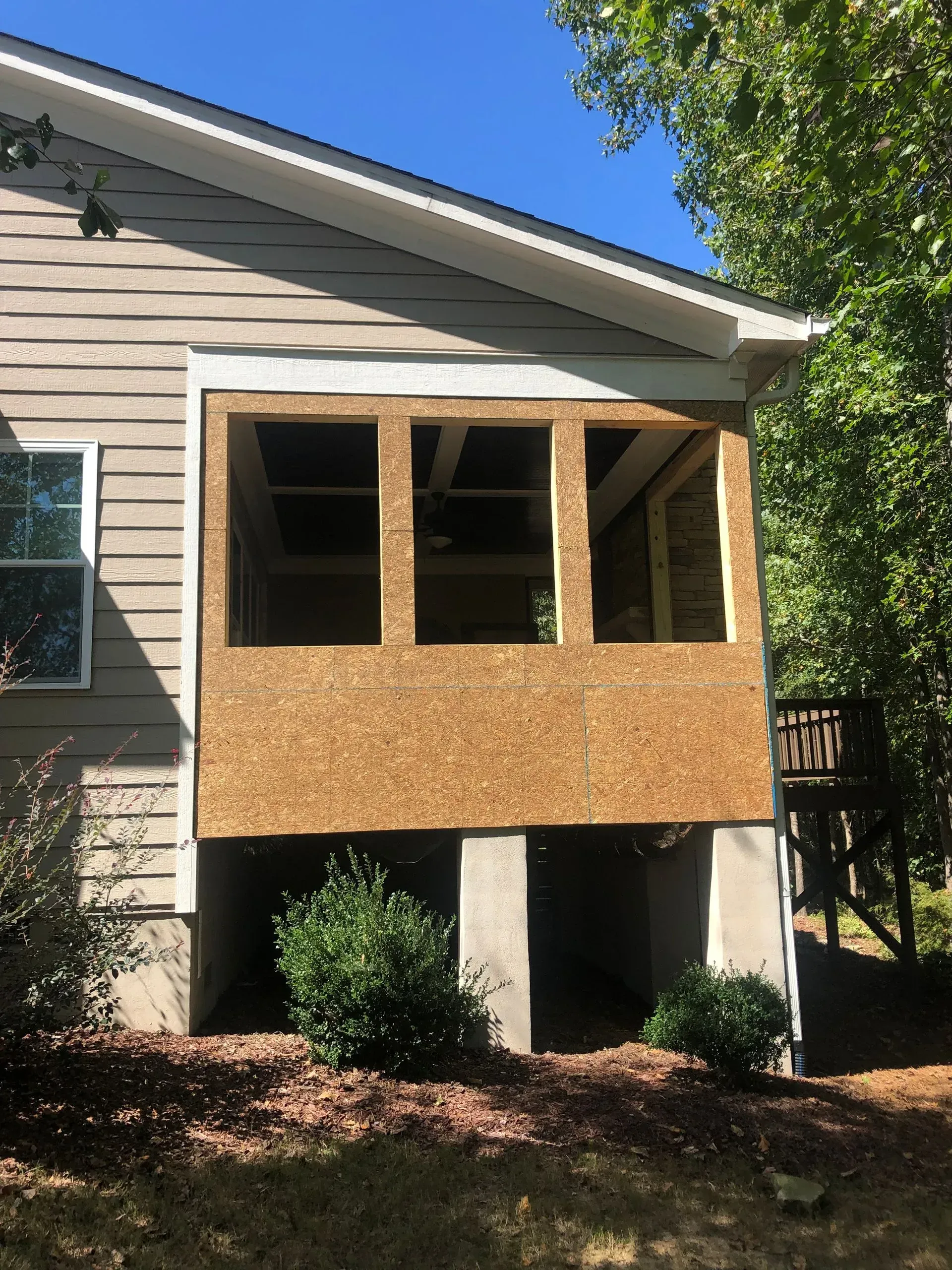 A house with unfinished wooden frame construction for a new porch.