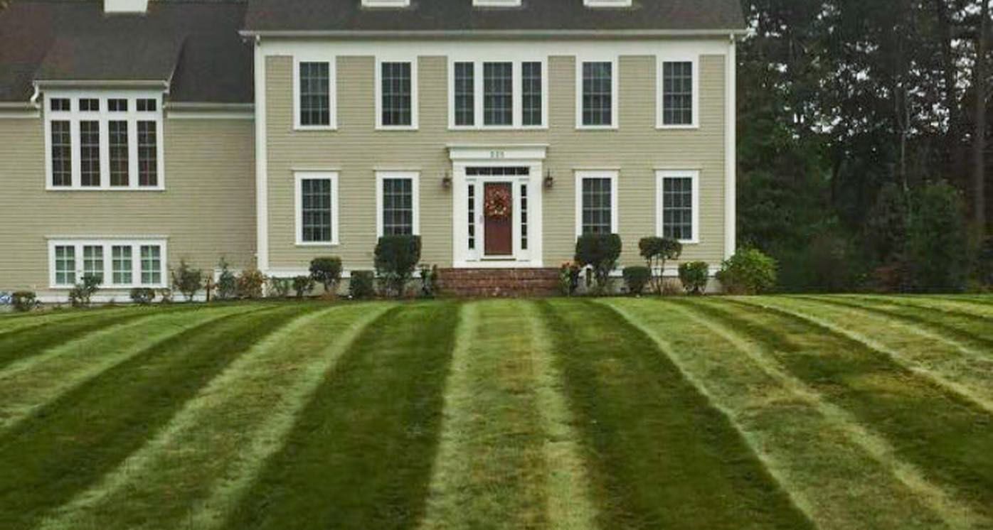 a large house with a lush green lawn in front of it