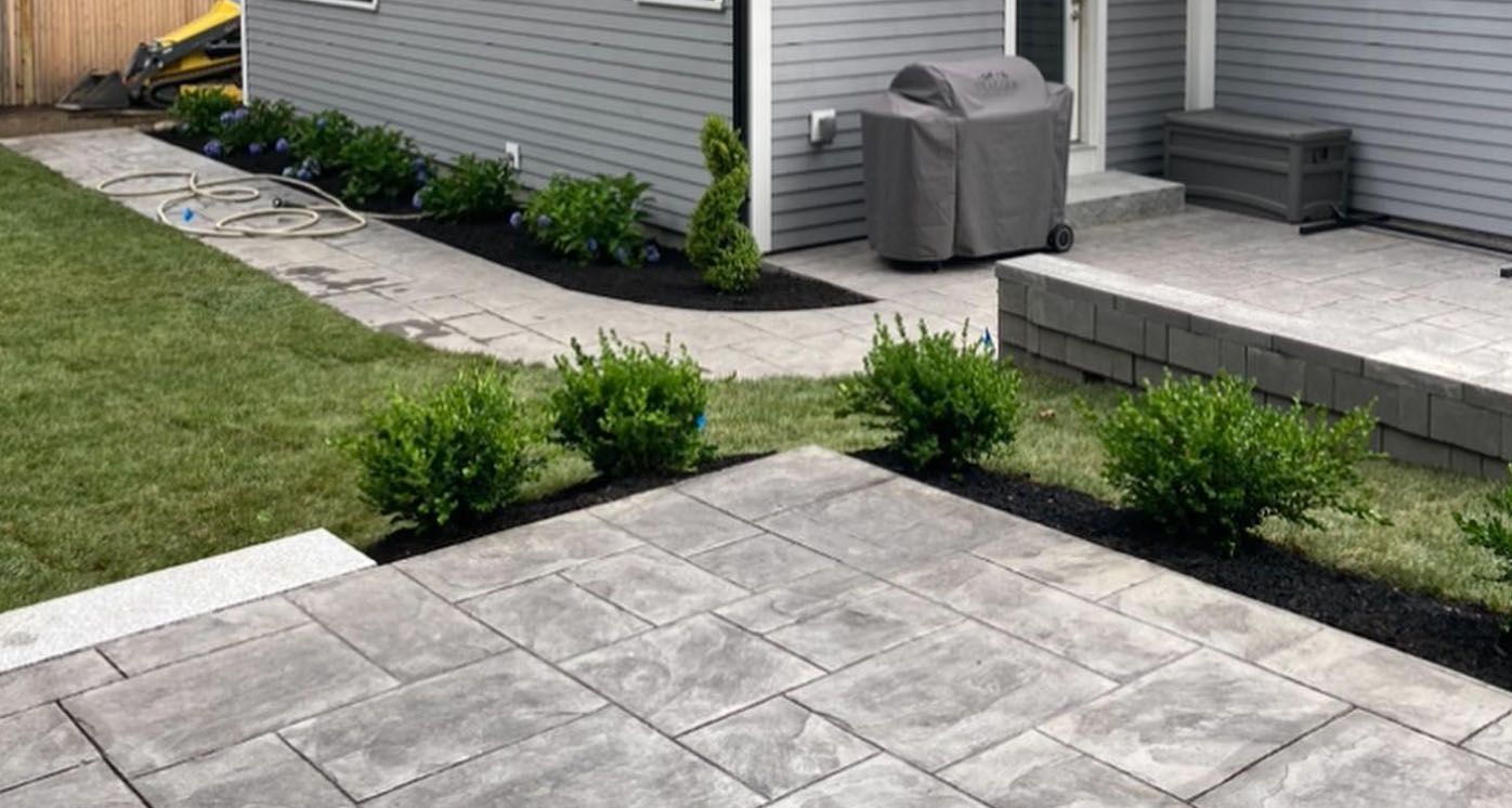 a patio with a grill in the backyard of a house