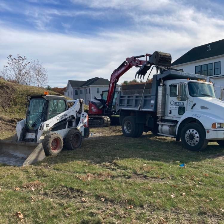 a dump truck and a bulldozer are parked in a grassy field