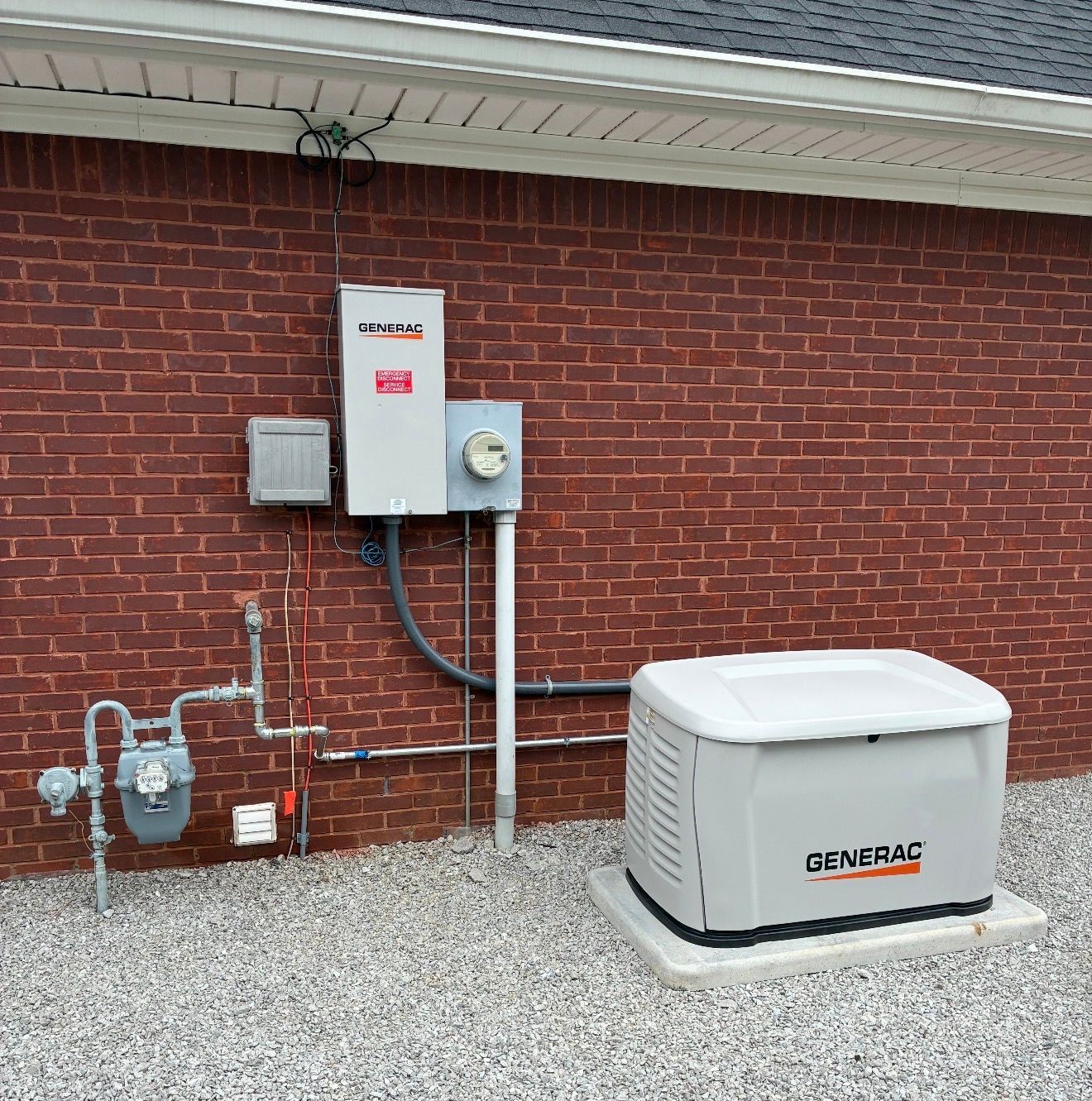 Brick house exterior with electrical meter, utility boxes, and a white Generac backup generator