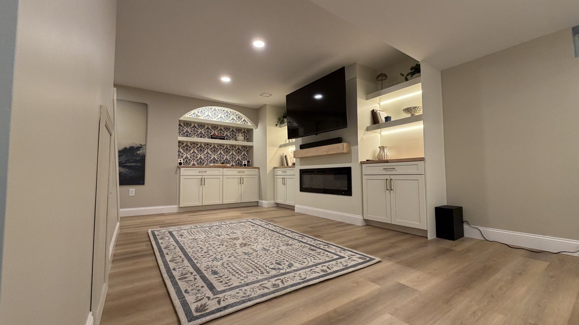 Entertainment room in basement with cabinets and tv