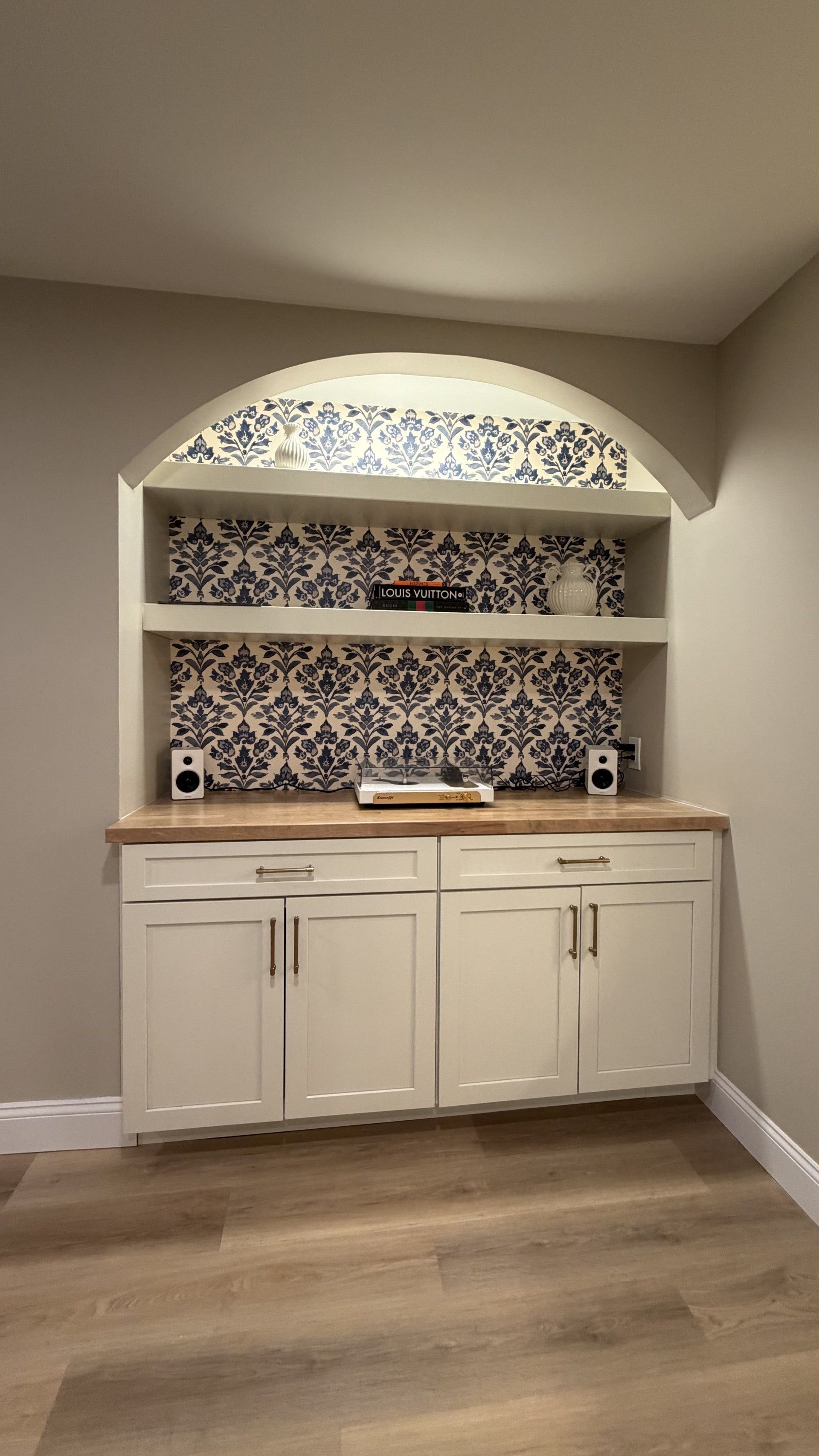 Cabinet in basement with black and white wallpaper
