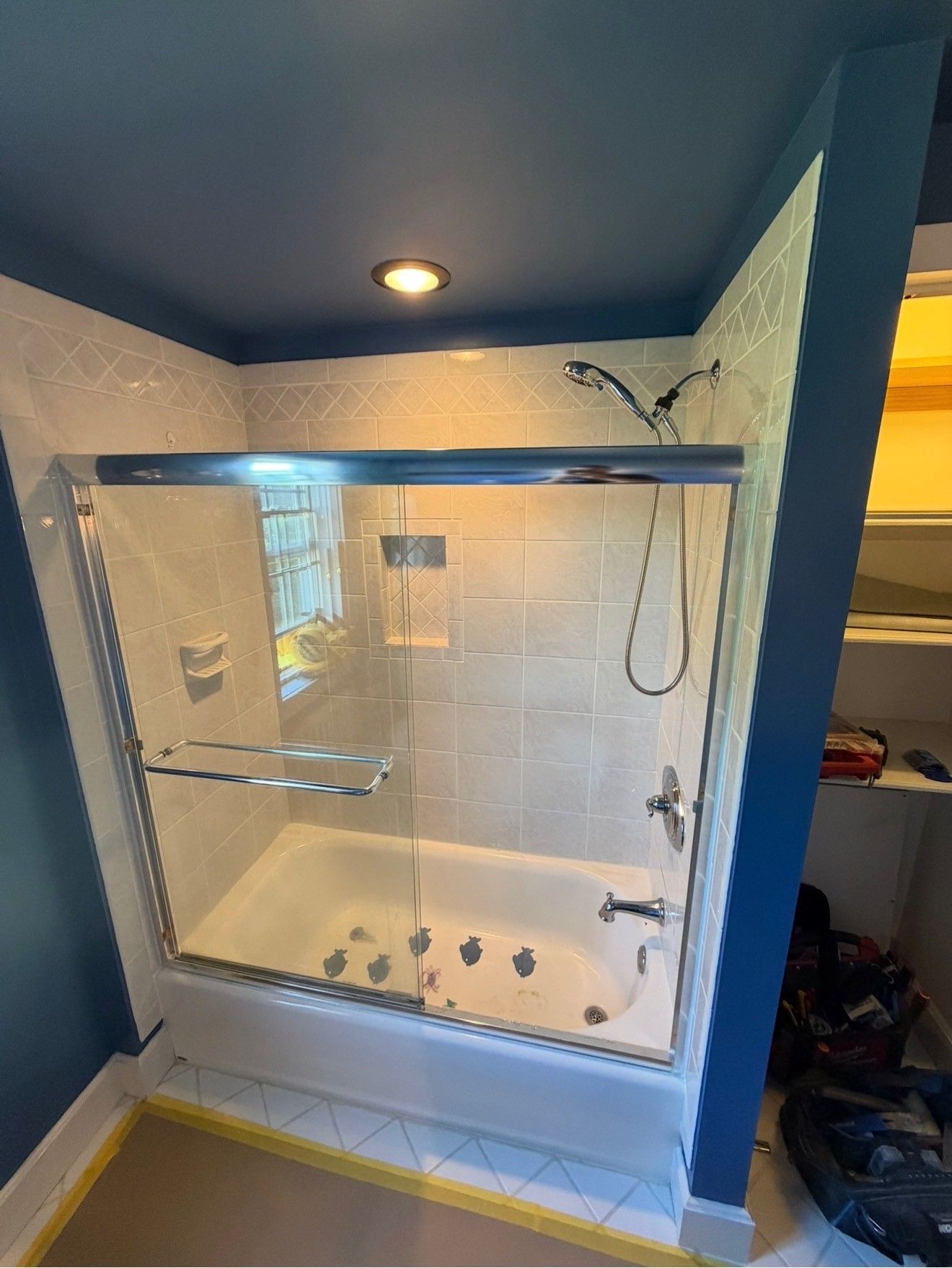 White-tiled bathroom with a glass shower enclosure
