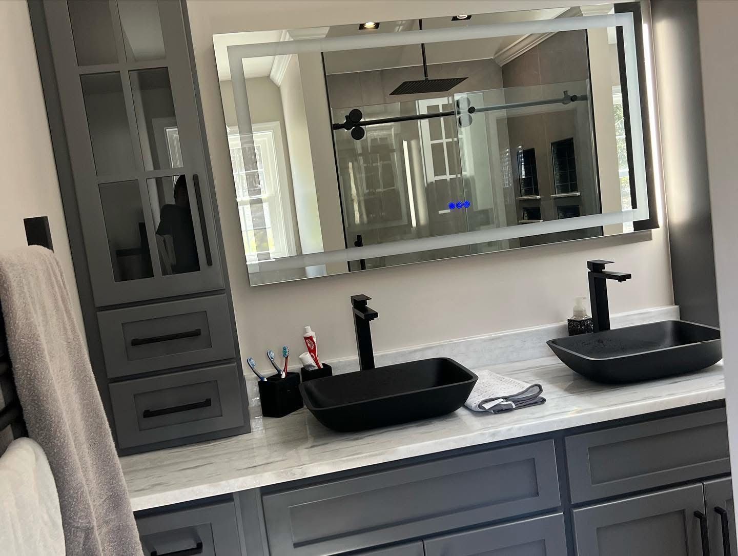 A bathroom with two sinks and a large mirror.
