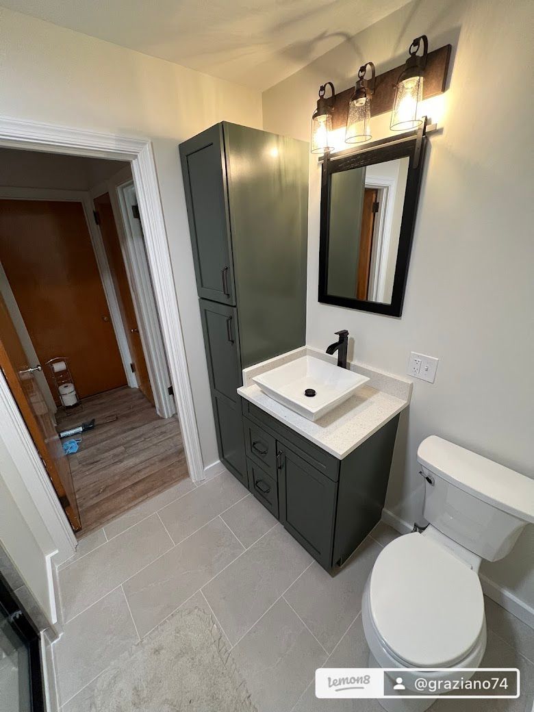 A bathroom with a sink , toilet and mirror.