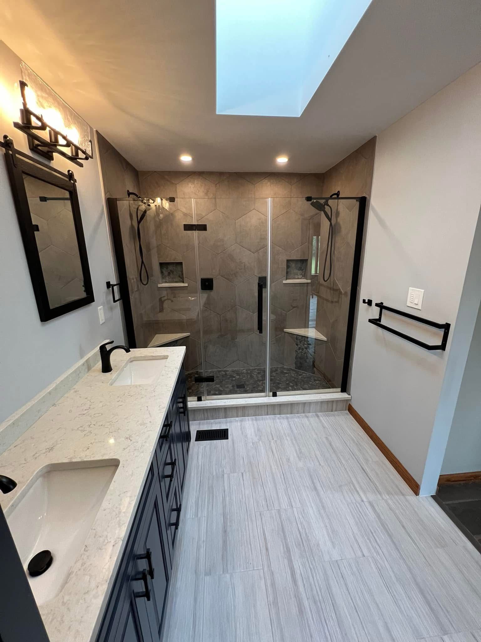 A bathroom with a sink , mirror , and walk in shower.
