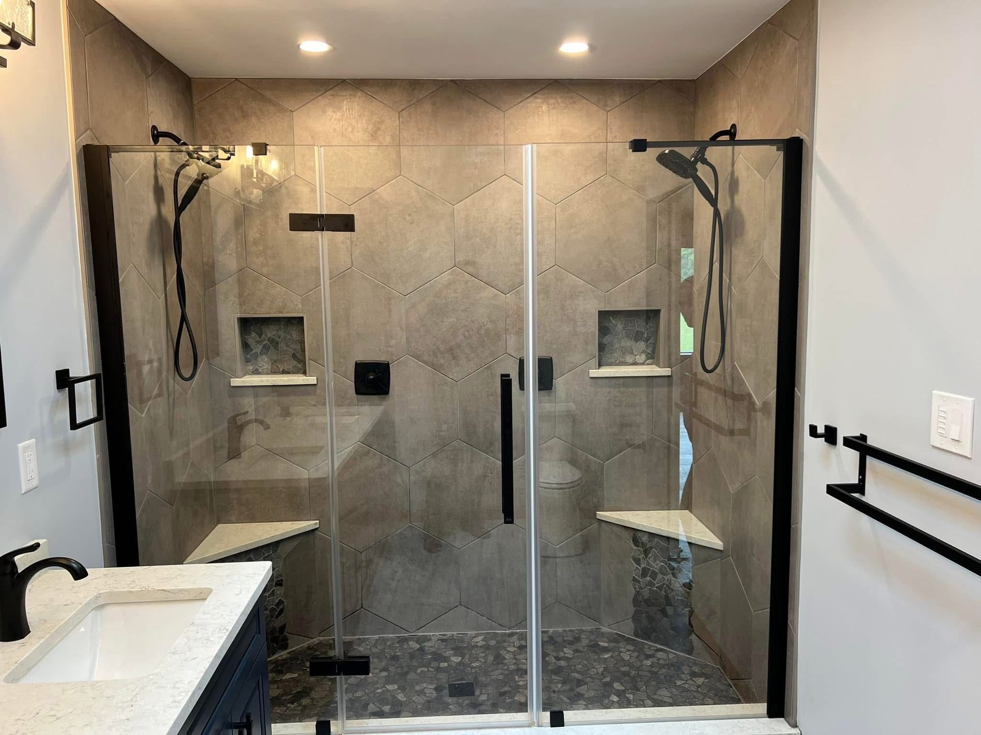 A bathroom with a walk in shower and a sink.