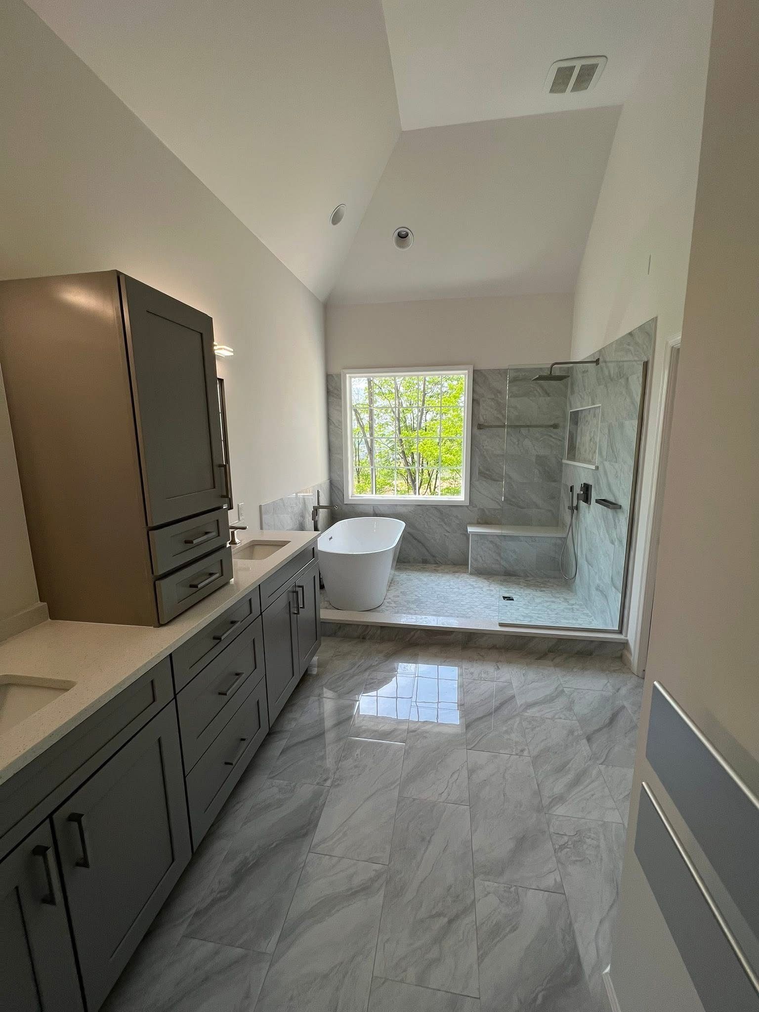 A bathroom with a tub , sink , and shower.
