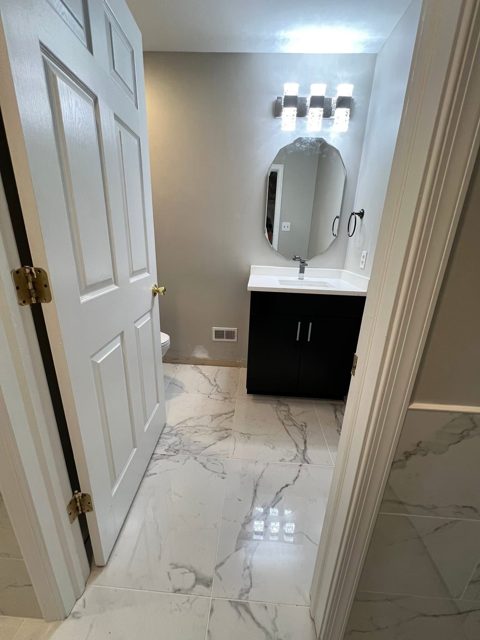 A bathroom with a sink , mirror and toilet.