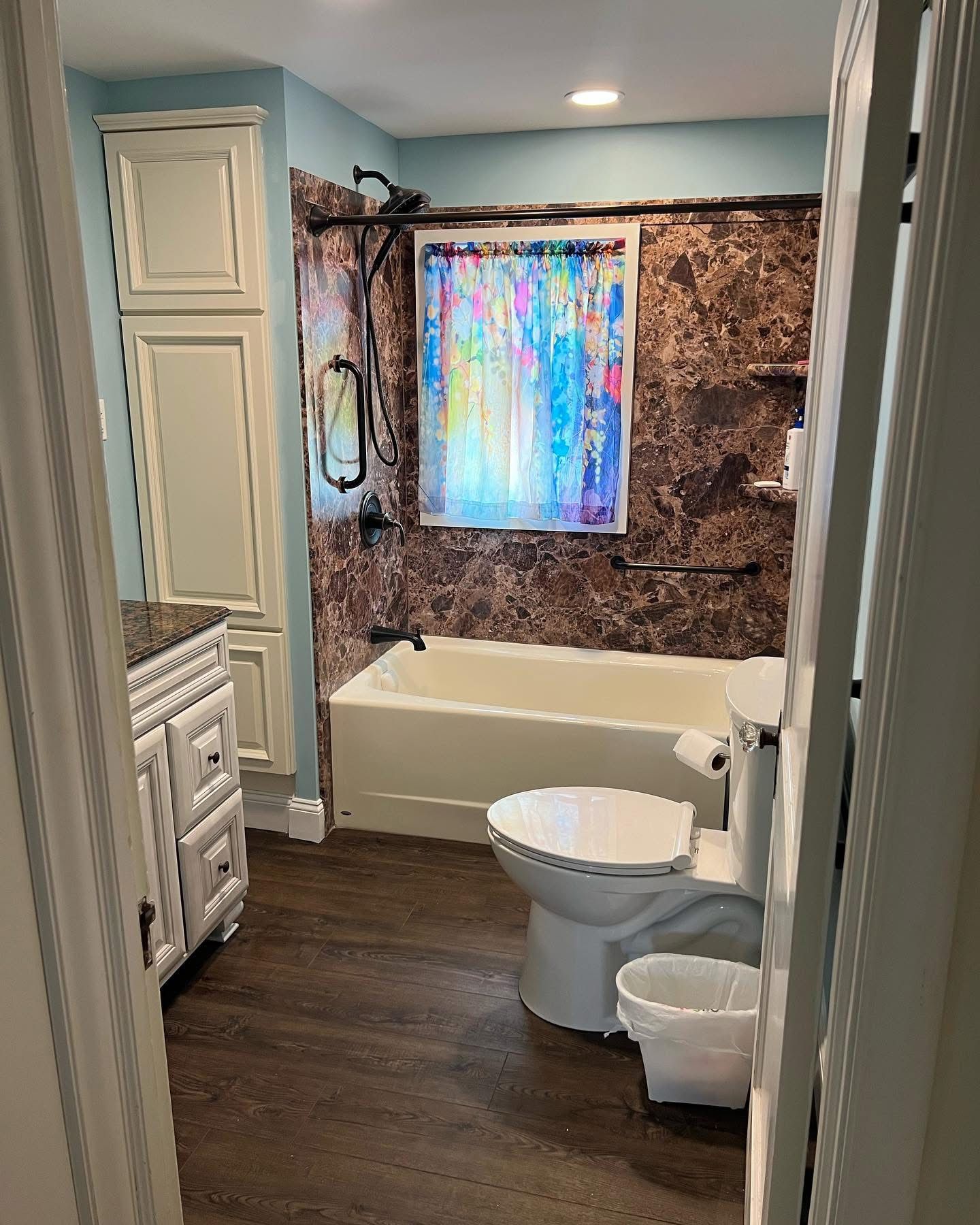 A bathroom with a toilet , sink , tub and shower.