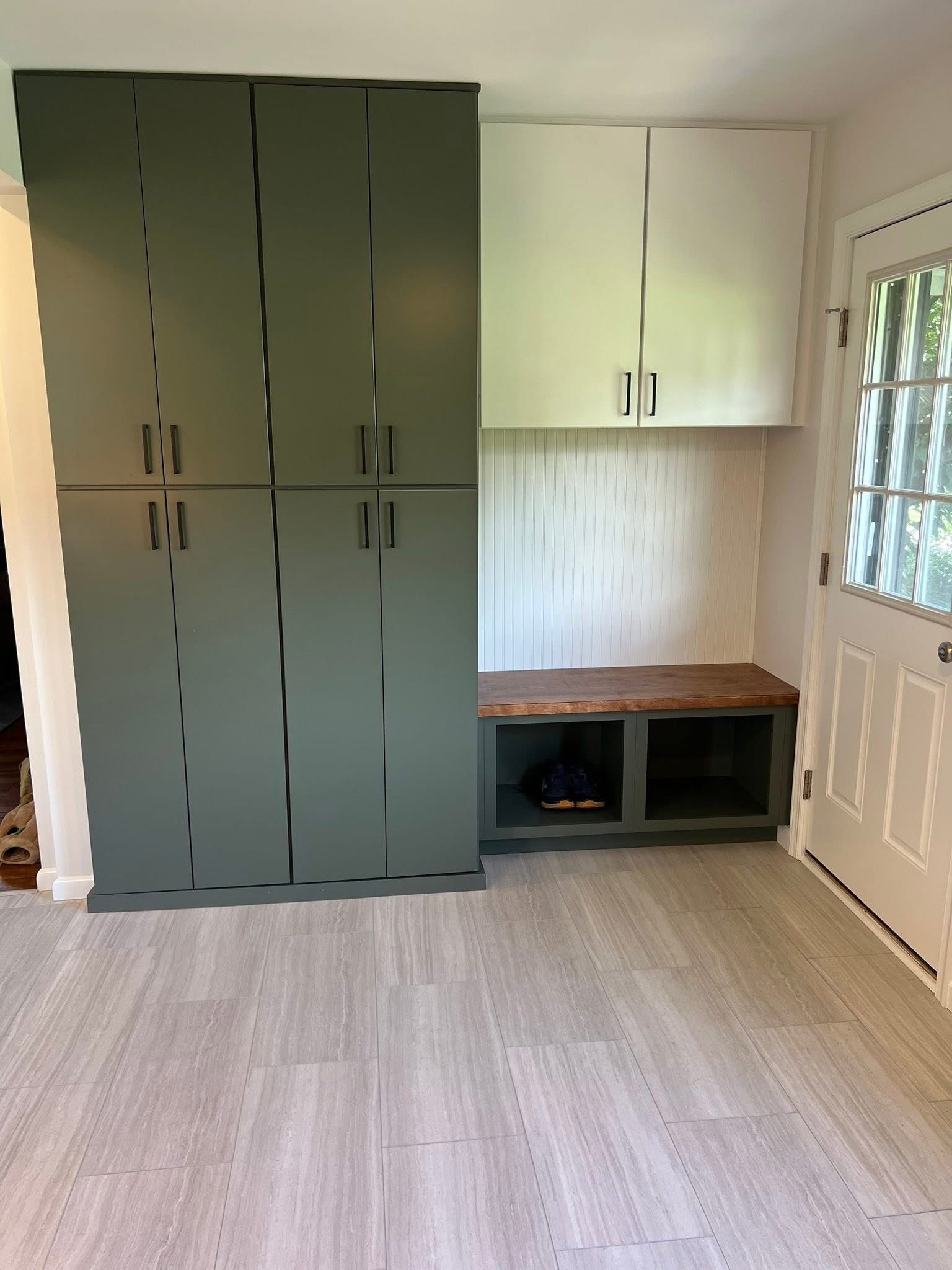 A room with a lot of cabinets and a bench.