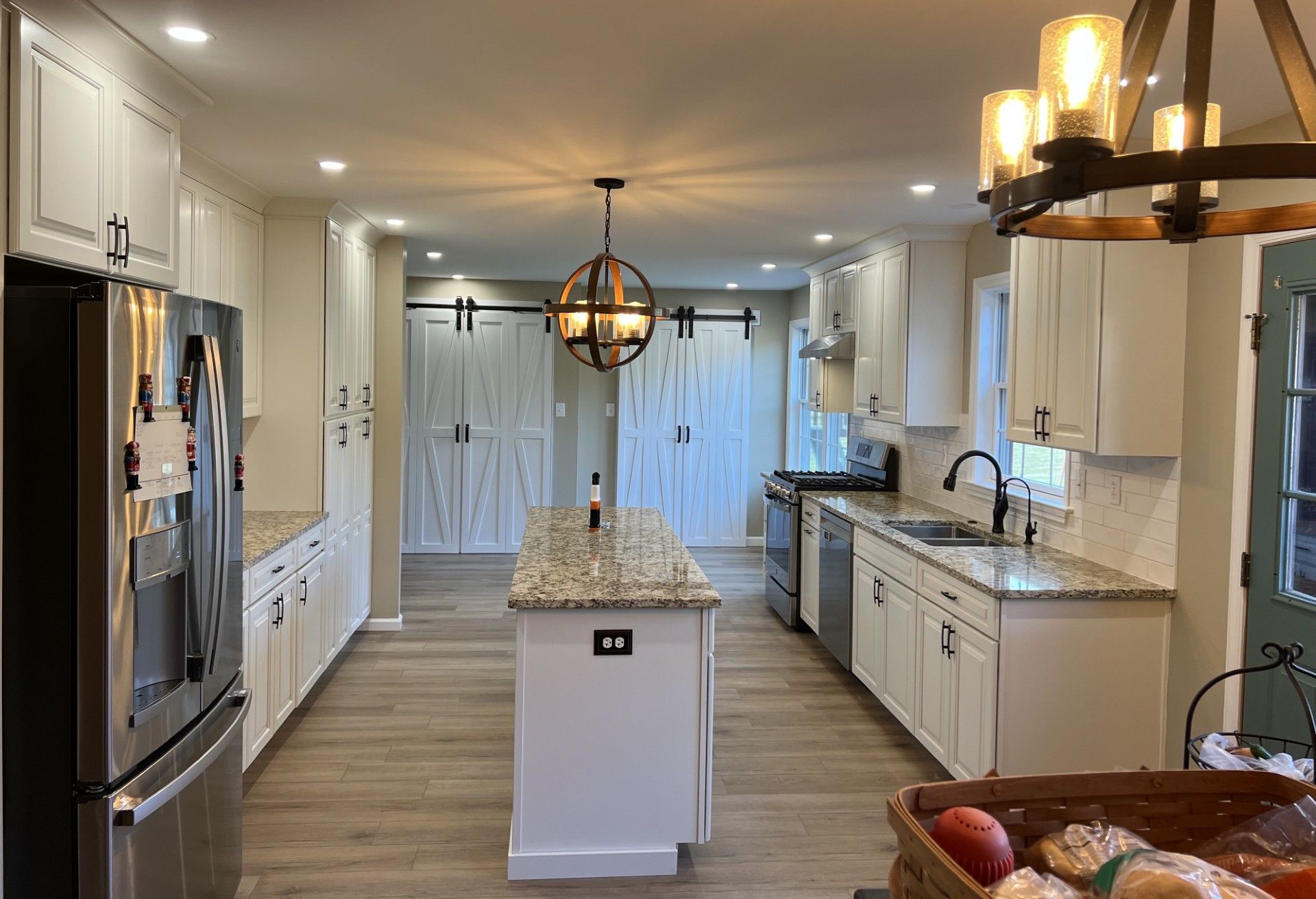 Modern kitchen with white cabinets, stainless steel appliances, and a central island. 
