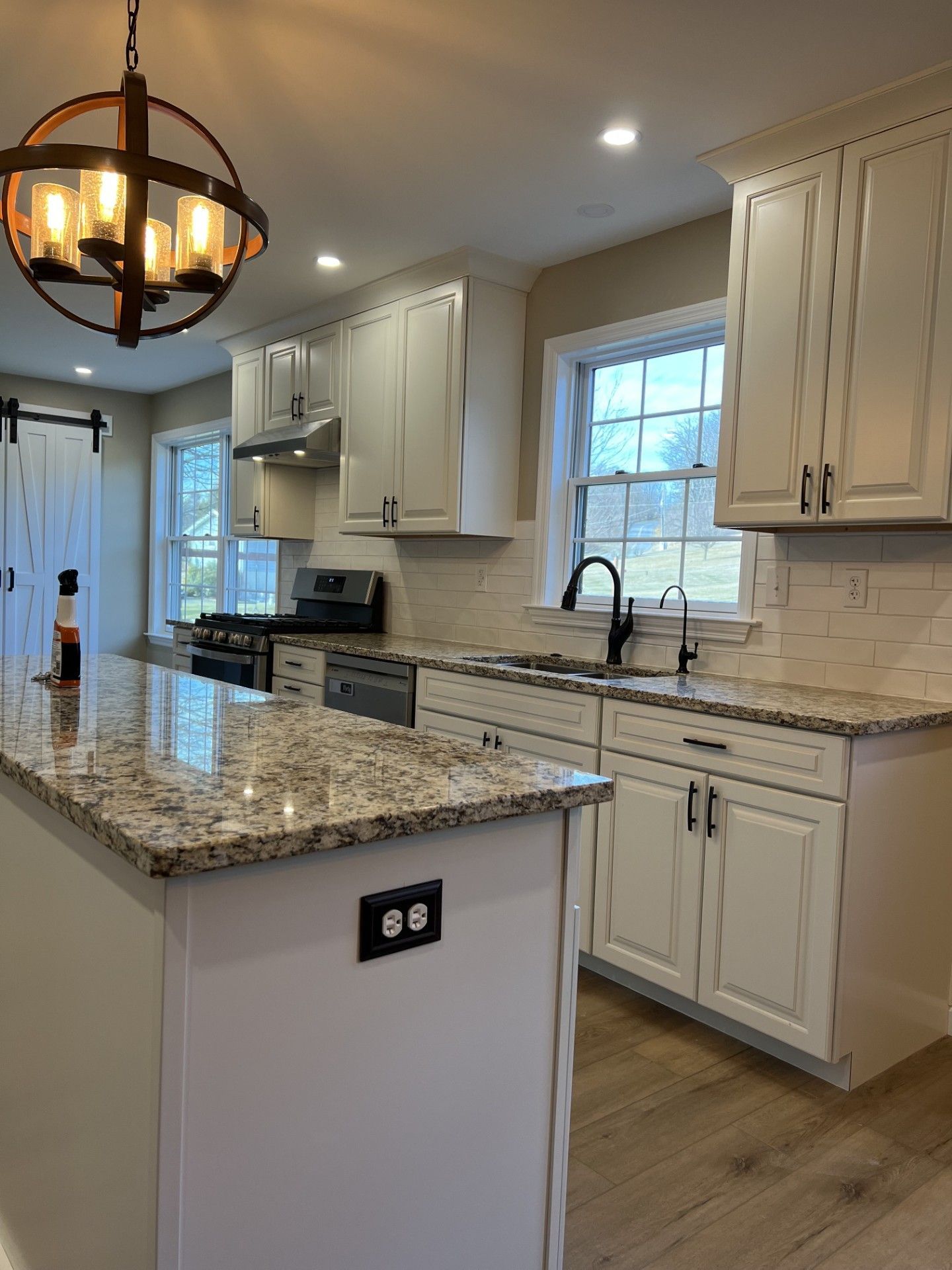 Bright, modern kitchen with white cabinets, granite countertops, and stainless steel appliances. 