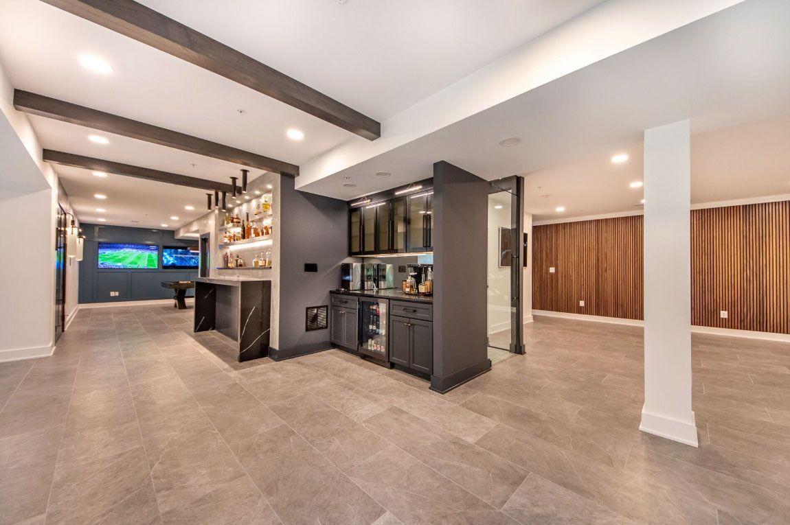A basement with a bar and a pool table.