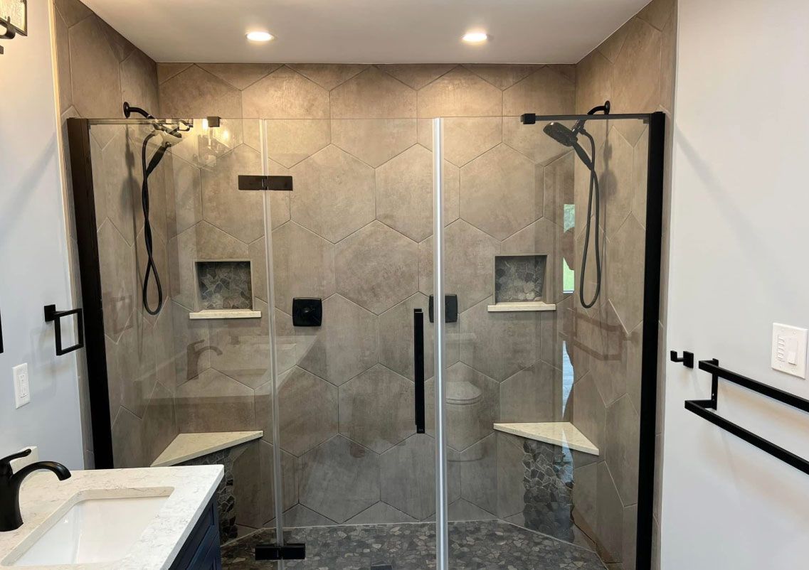 A bathroom with a walk in shower and a sink.