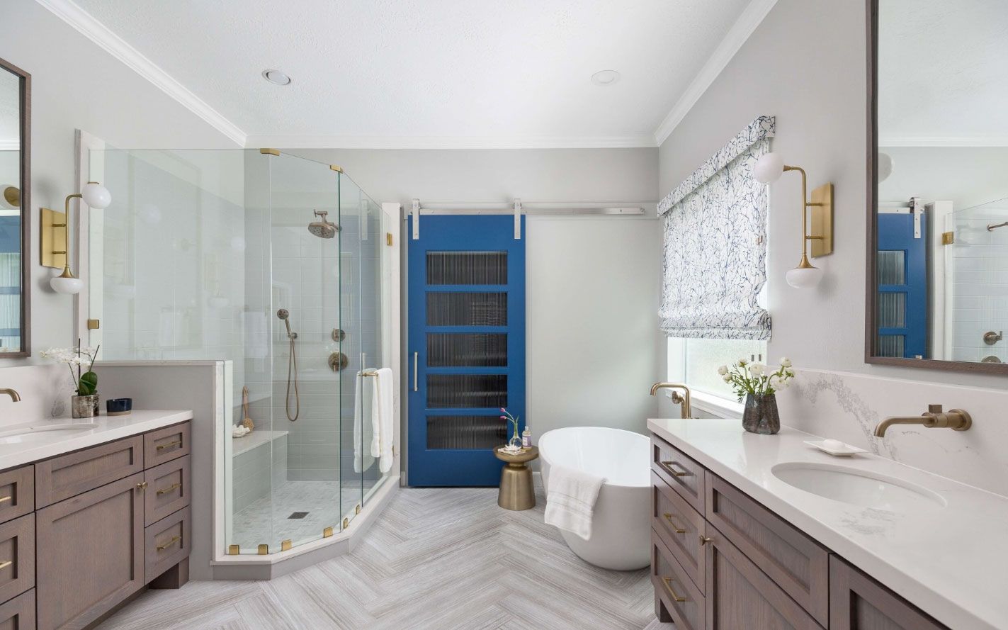 A bathroom with two sinks , a tub , a shower and a blue door.