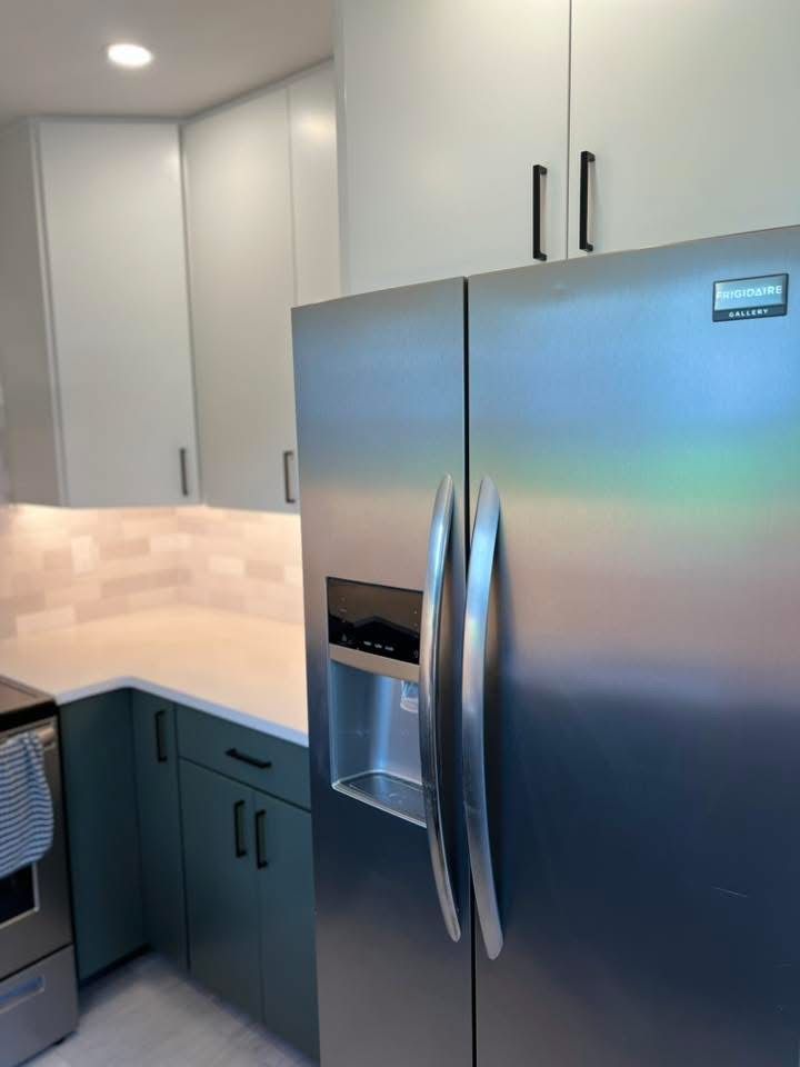 A kitchen with stainless steel cabinets and a stainless steel refrigerator.