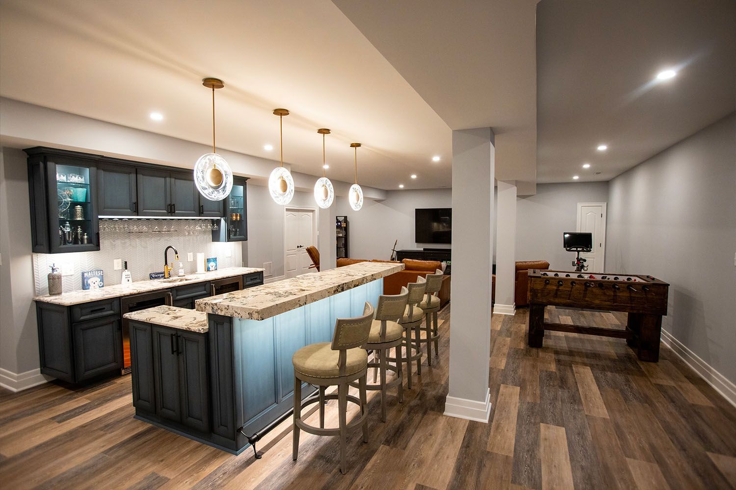 A basement with a bar and a foosball table.