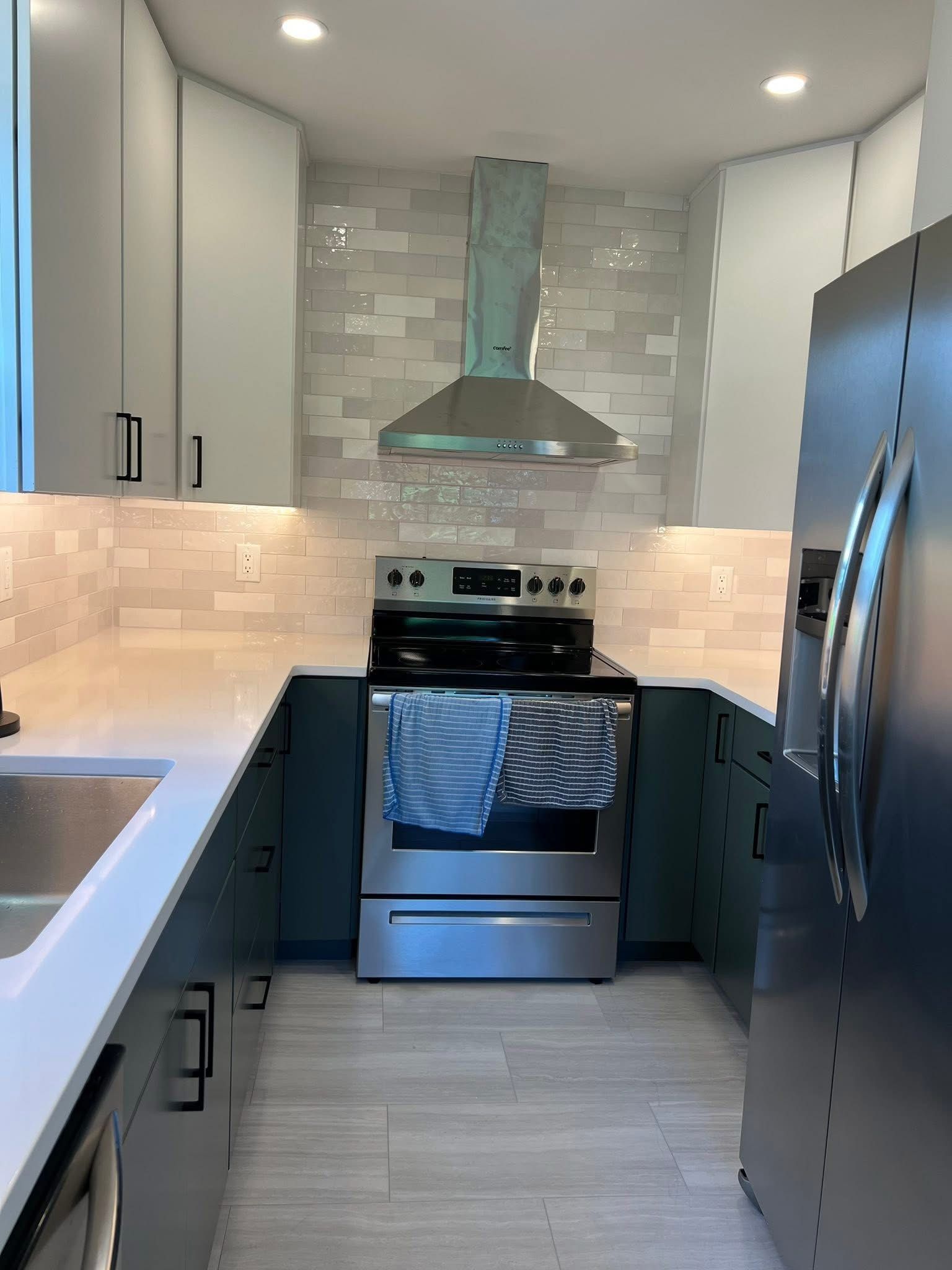 A kitchen with a stove , sink , and refrigerator