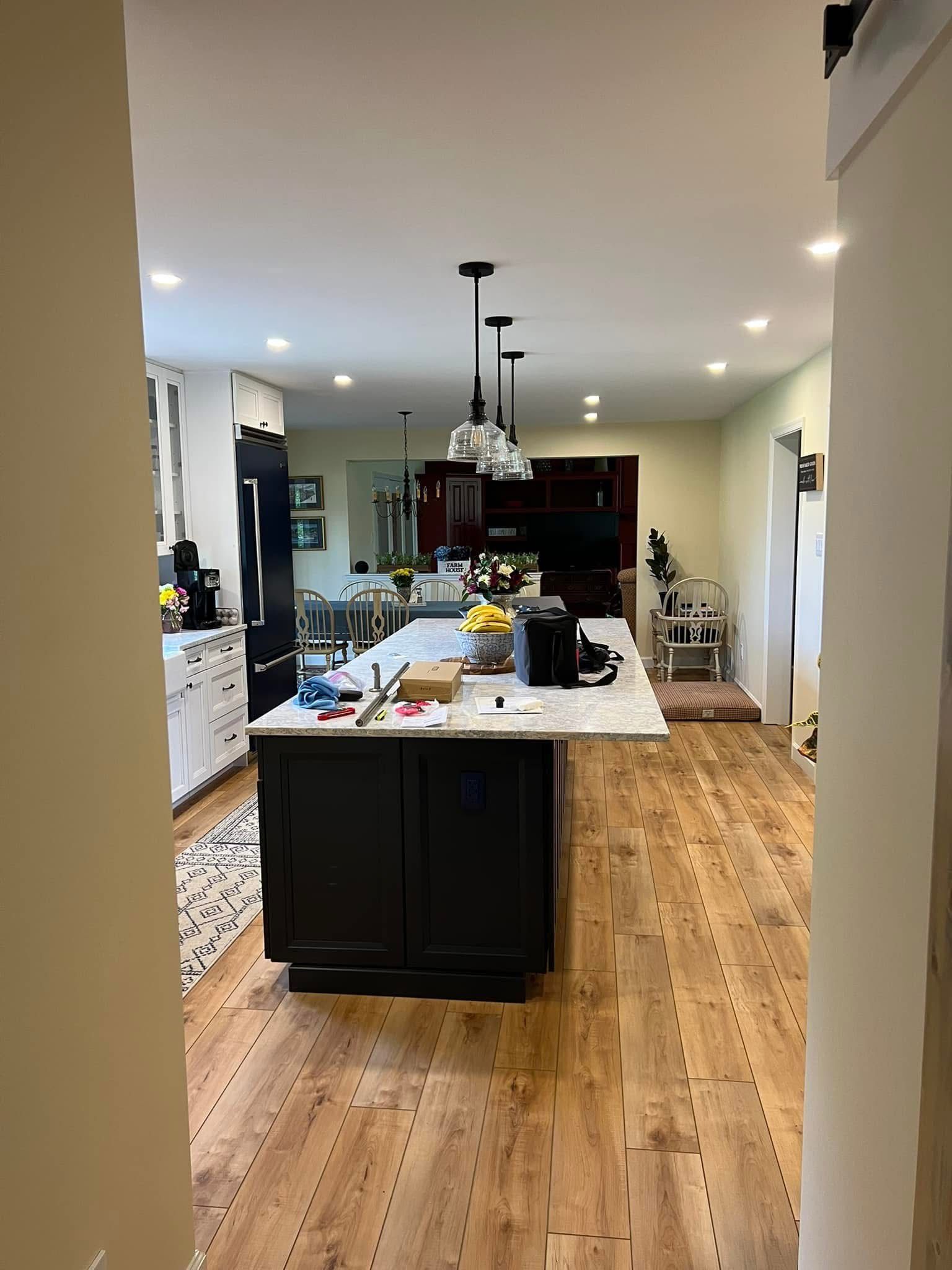 A kitchen with a large island and hardwood floors.