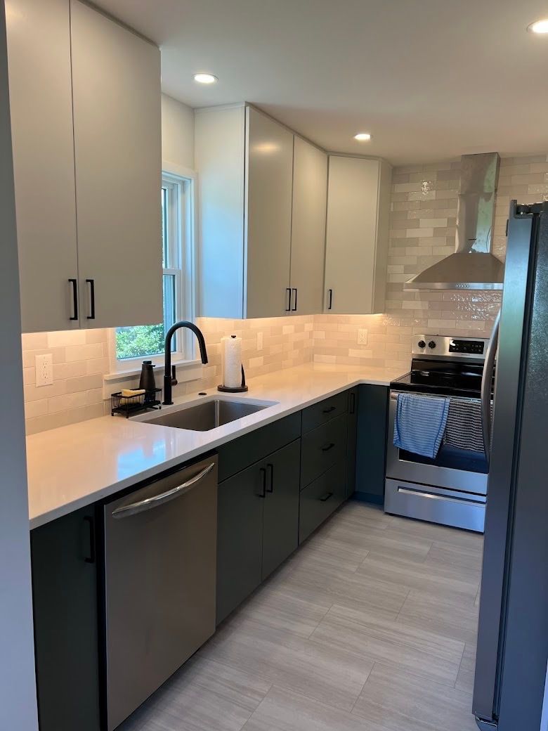 A kitchen with a sink , stove , refrigerator and dishwasher.