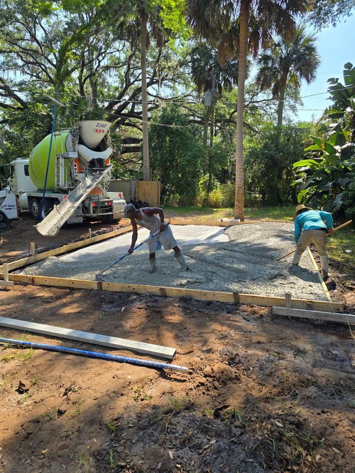 A concrete truck is pouring concrete into a yard.