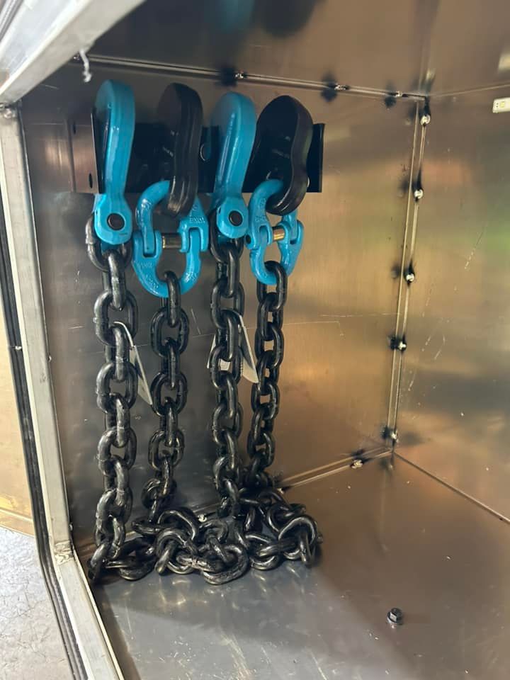 Blue chain hoists hanging inside a metal storage compartment