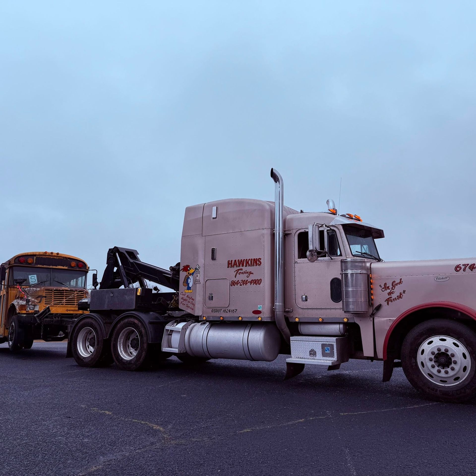 Tow truck hauling a yellow car on a roadside under a cloudy sky